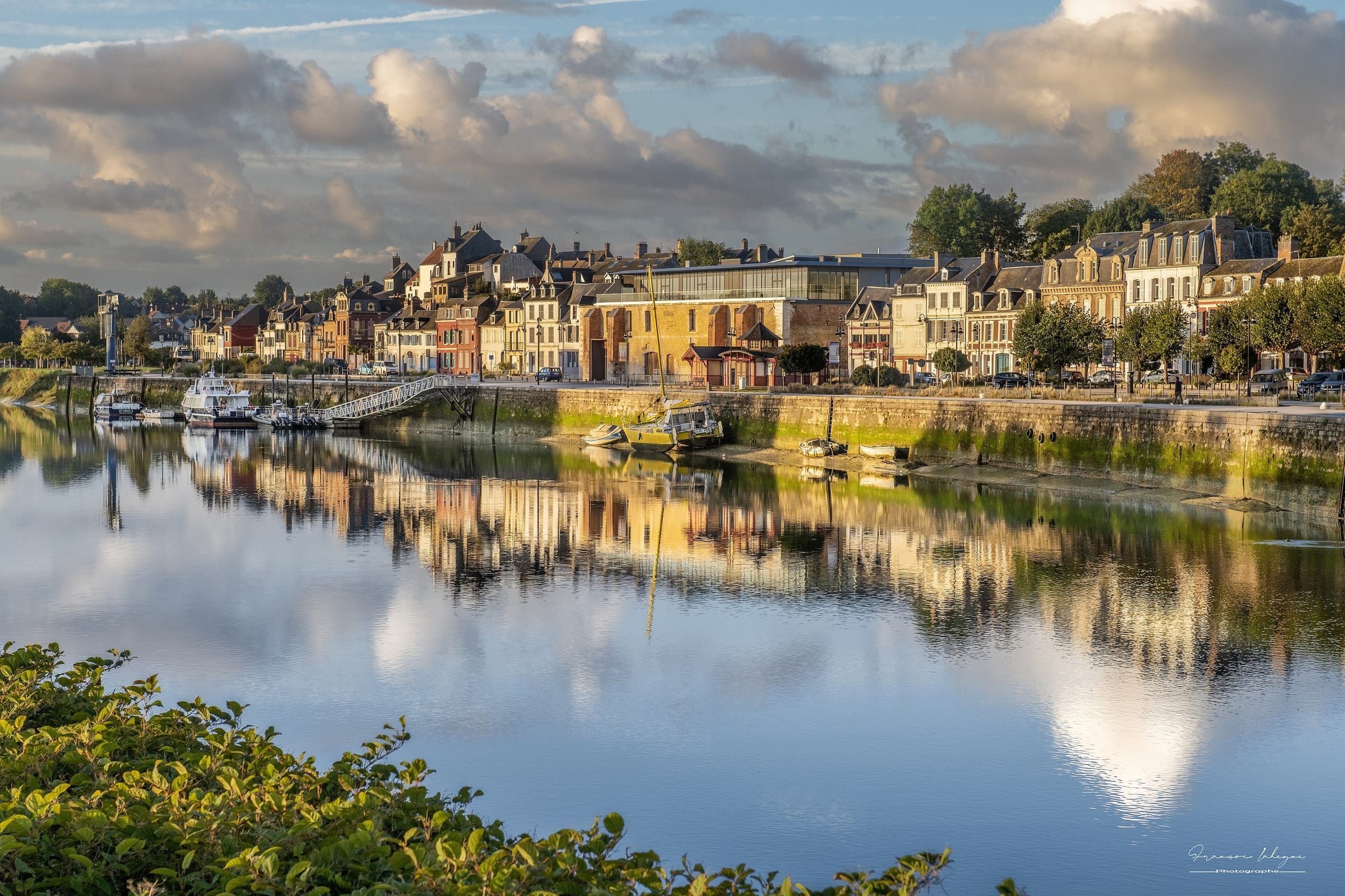 Le port de Saint-Valery-sur-Somme dans une lumière dorée, les maisons du quai reflétées dans l’eau calme